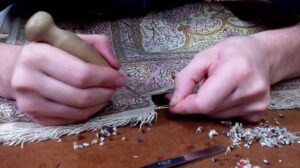 Vorbereitung eines Seidenteppichs für die Restaurierung der Fransen